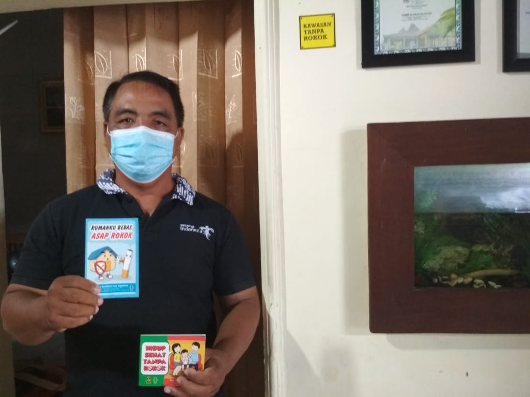 Tri Handoko Putra menunjukkan buku panduan rumah bebas asap rokok di lingkungan RW 04 Wirobrajan. (Foto: Somad)
